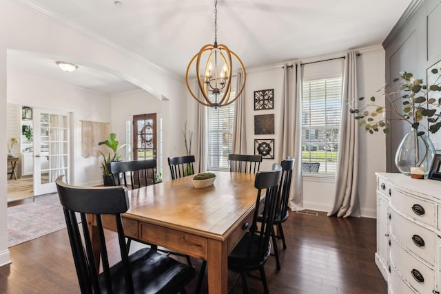 dining area with dark hardwood / wood-style flooring, ornamental molding, and a chandelier