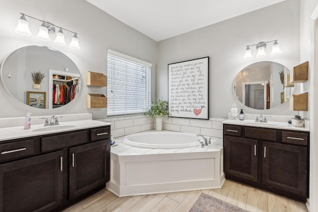 bathroom featuring hardwood / wood-style flooring, vanity, and a washtub