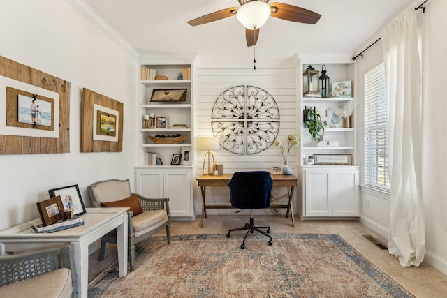 office area with ornamental molding, light colored carpet, ceiling fan, and built in shelves