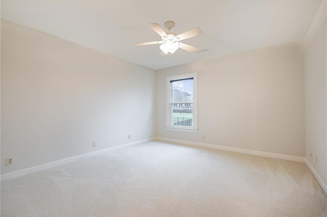 empty room featuring light colored carpet and ceiling fan