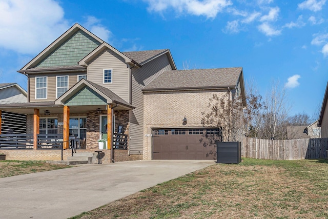 view of front of home featuring a garage, a front yard, and covered porch