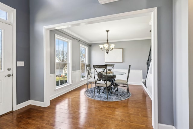 dining area featuring crown molding, dark hardwood / wood-style floors, and a notable chandelier