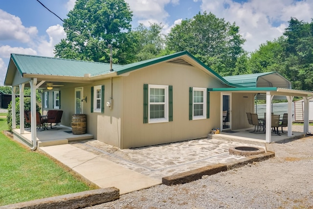 rear view of property featuring an outdoor fire pit and a patio area