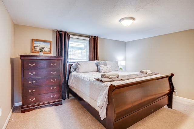 bedroom featuring light carpet and a textured ceiling