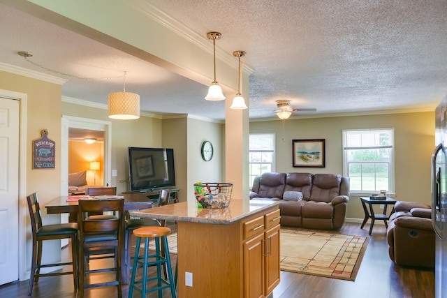 kitchen featuring plenty of natural light, decorative light fixtures, a center island, and a breakfast bar area