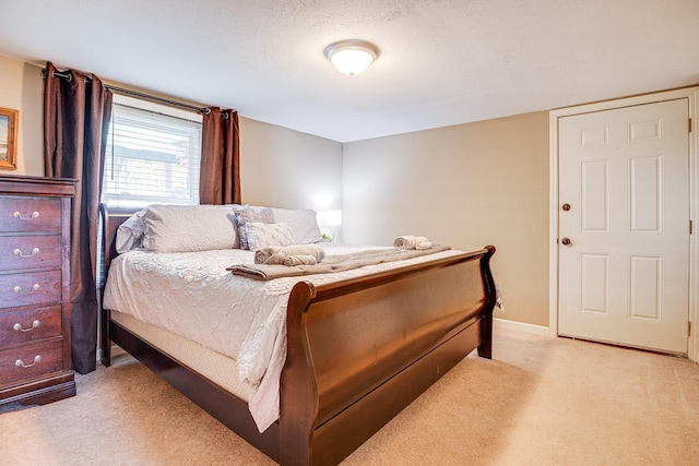 bedroom featuring light colored carpet and a textured ceiling