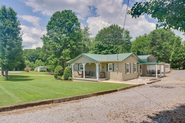 view of front of house with a patio, a storage unit, and a front yard