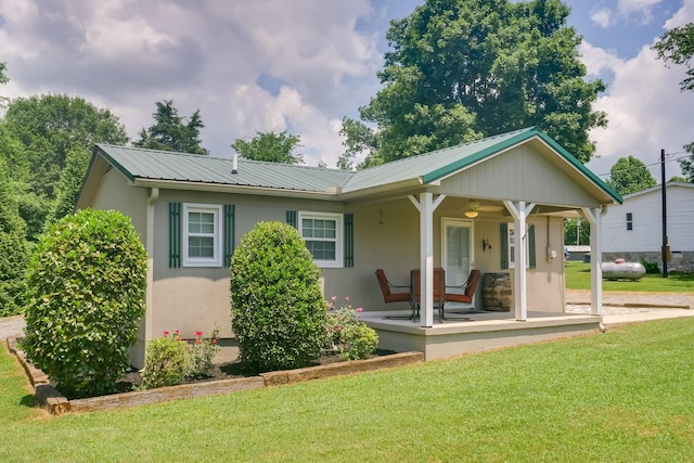 back of property with a porch and a yard