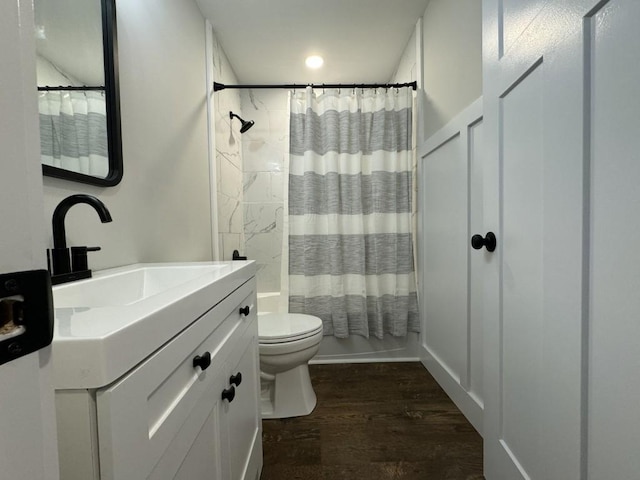 full bathroom featuring toilet, hardwood / wood-style floors, vanity, and shower / bath combo with shower curtain