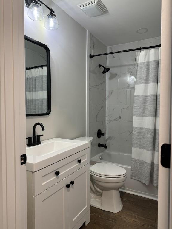 full bathroom with vanity, hardwood / wood-style flooring, toilet, and shower / bathtub combination with curtain