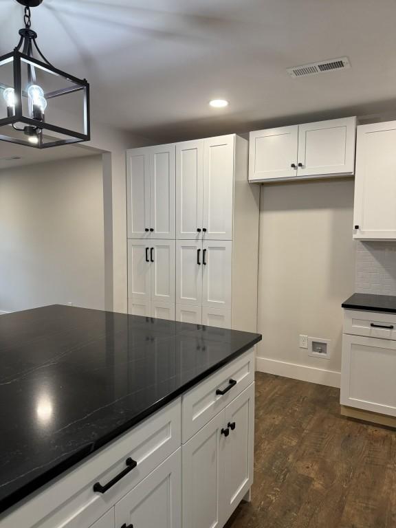 kitchen with an inviting chandelier, hanging light fixtures, dark hardwood / wood-style floors, tasteful backsplash, and white cabinets