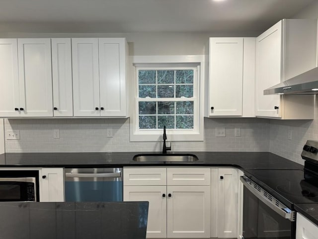 kitchen featuring appliances with stainless steel finishes, sink, wall chimney range hood, and white cabinets