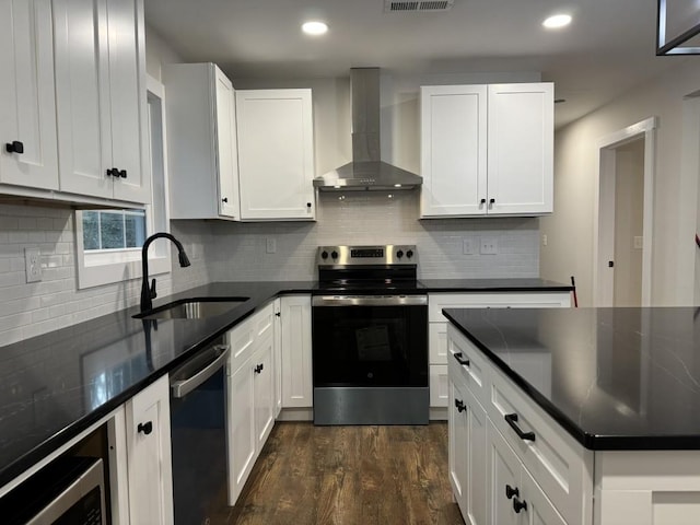 kitchen with white cabinetry, appliances with stainless steel finishes, sink, and wall chimney range hood