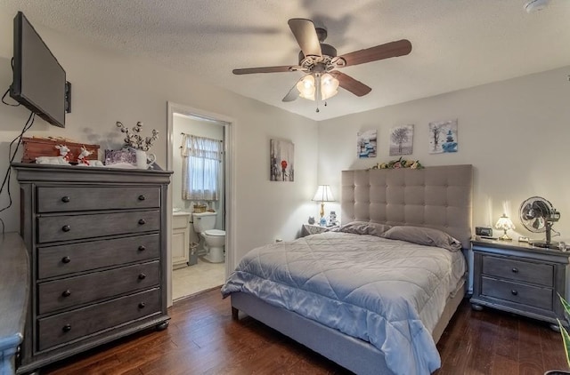 bedroom with dark wood-type flooring, ensuite bath, ceiling fan, and a textured ceiling