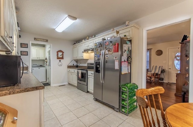 kitchen featuring light tile patterned floors, appliances with stainless steel finishes, backsplash, a textured ceiling, and washer / clothes dryer