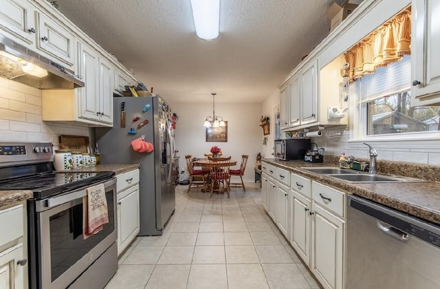 kitchen with sink, light tile patterned floors, stainless steel appliances, and white cabinets