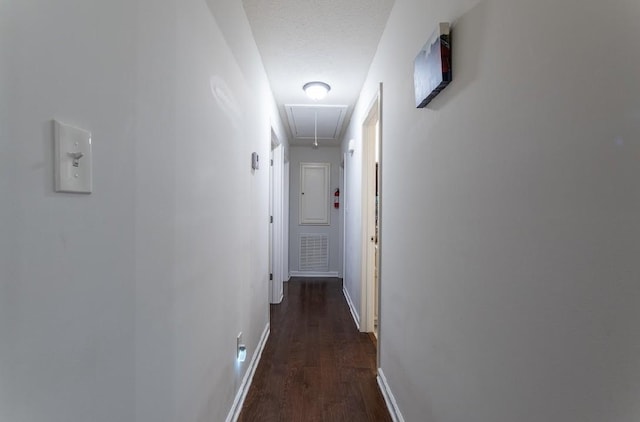 hall with dark hardwood / wood-style floors and a textured ceiling