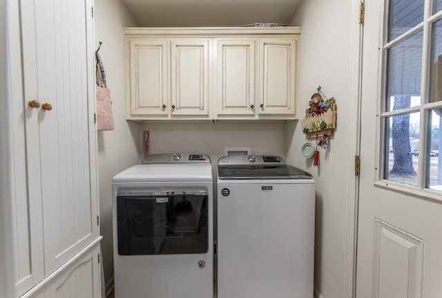 laundry area featuring washer and clothes dryer and cabinets