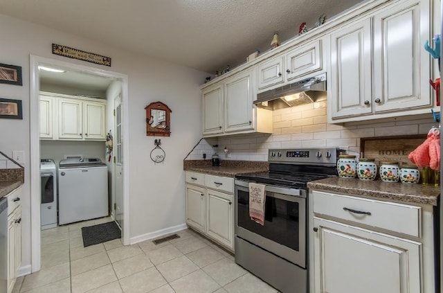 kitchen with light tile patterned flooring, appliances with stainless steel finishes, white cabinetry, separate washer and dryer, and backsplash