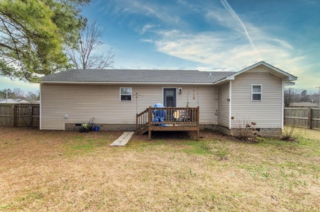 rear view of property with a wooden deck and a yard