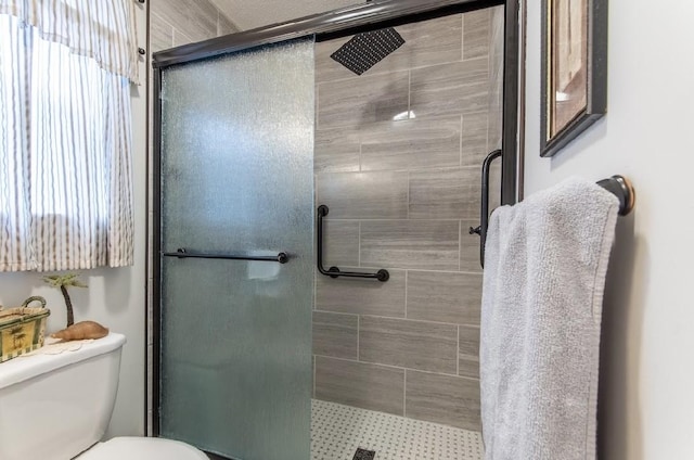 bathroom featuring walk in shower and toilet