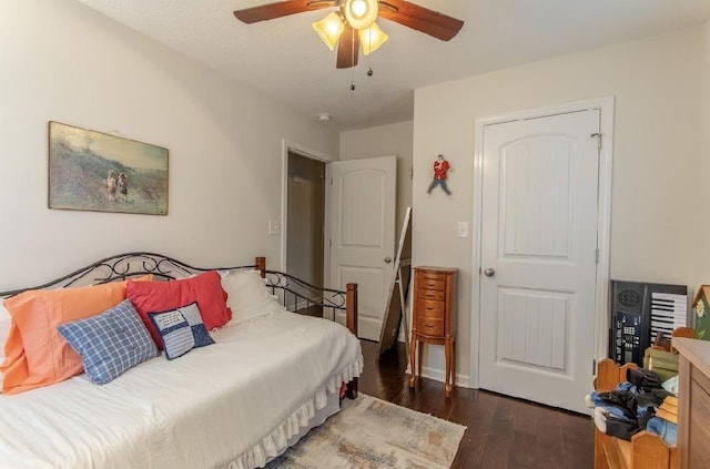 bedroom with dark hardwood / wood-style flooring and ceiling fan