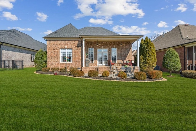 rear view of property with french doors and a lawn