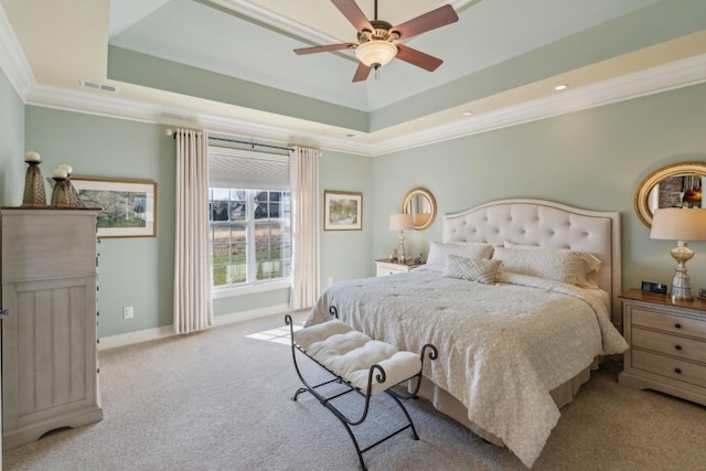 bedroom with ornamental molding, light carpet, ceiling fan, and a tray ceiling