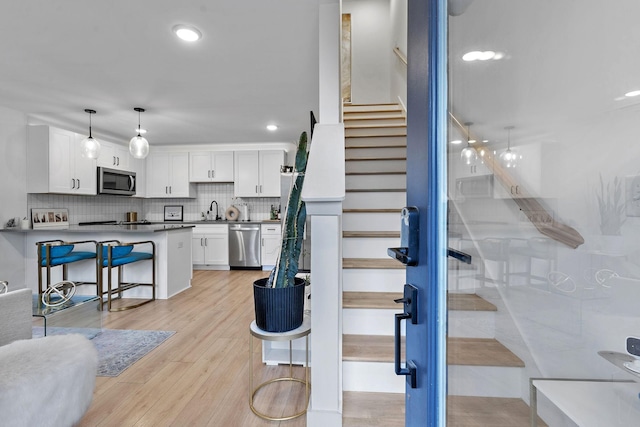 staircase featuring sink and wood-type flooring