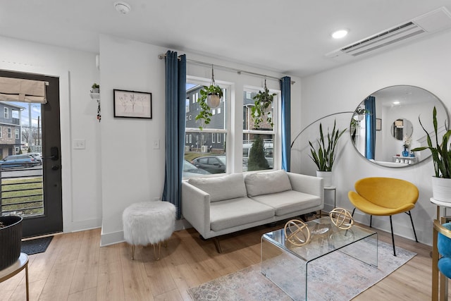 living room featuring a healthy amount of sunlight and light hardwood / wood-style flooring