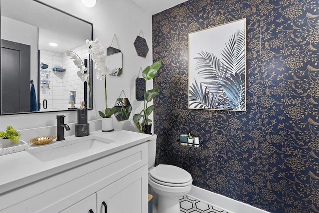 bathroom with vanity, toilet, and a shower