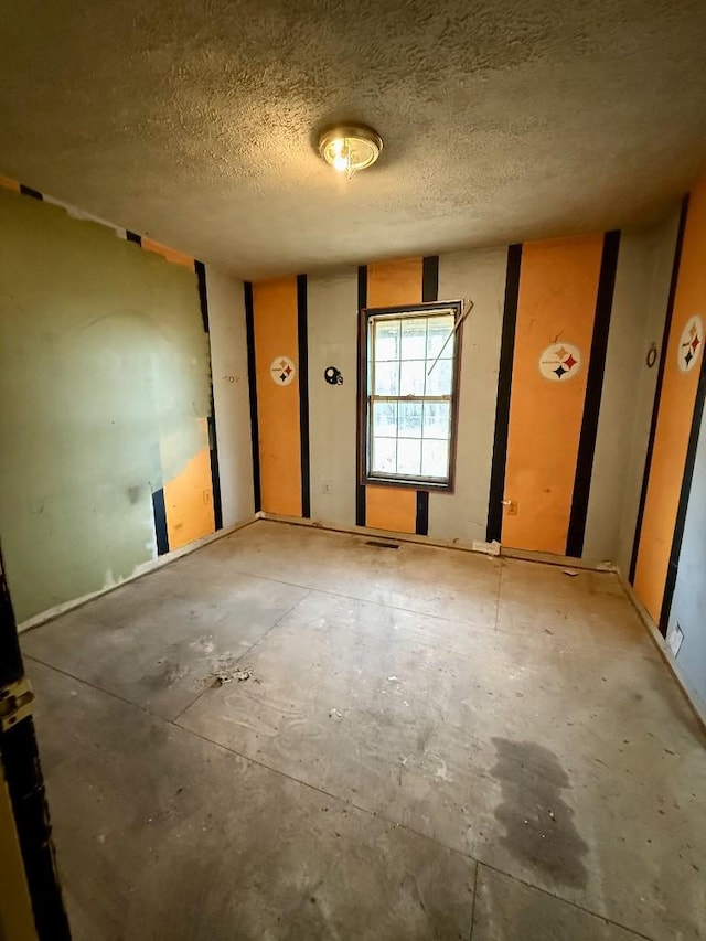 unfurnished room featuring a textured ceiling