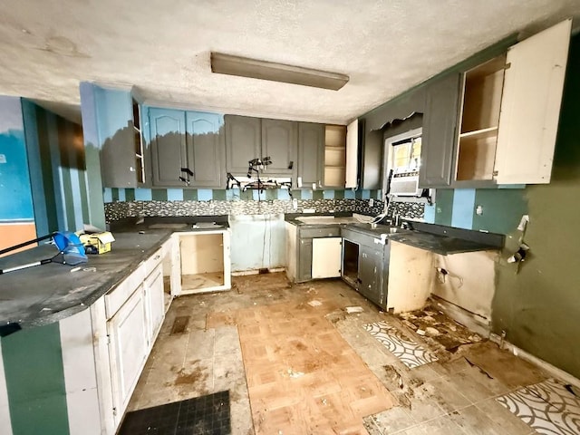 kitchen with cooling unit, backsplash, gray cabinets, and a textured ceiling