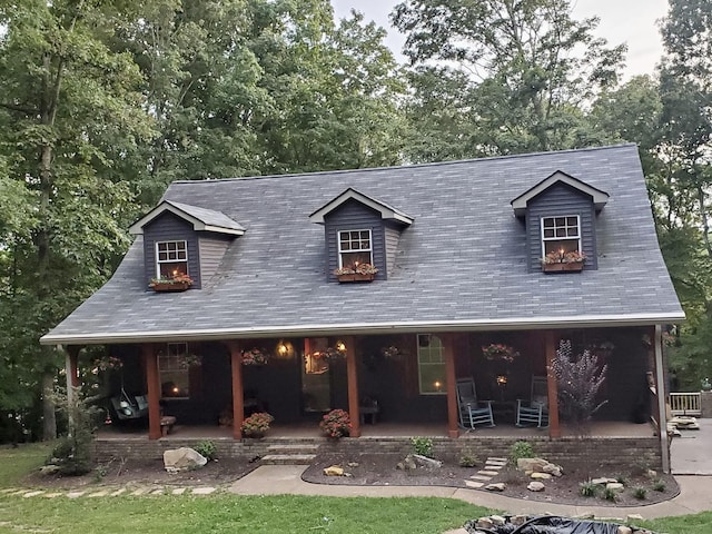 cape cod-style house with covered porch