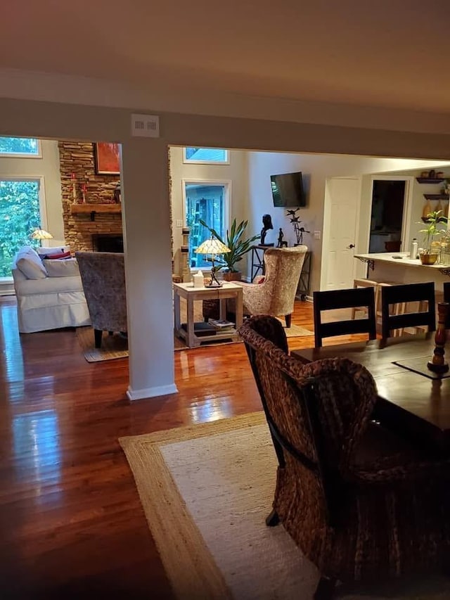 living room with a fireplace, visible vents, and wood finished floors