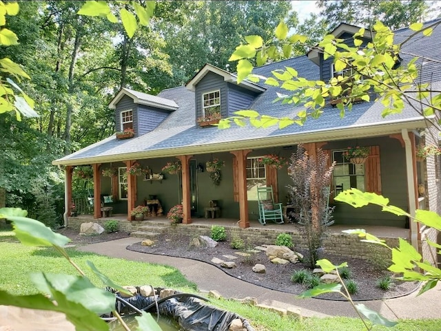 view of front of home with covered porch and a shingled roof