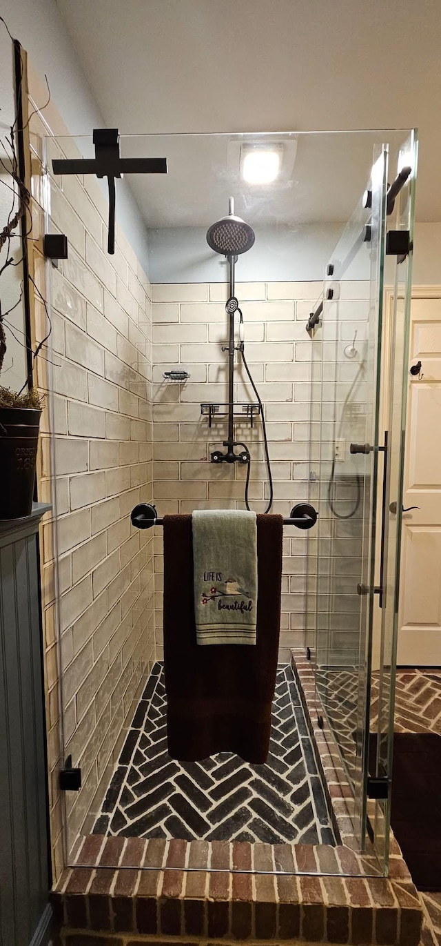 full bathroom with a stall shower and brick floor