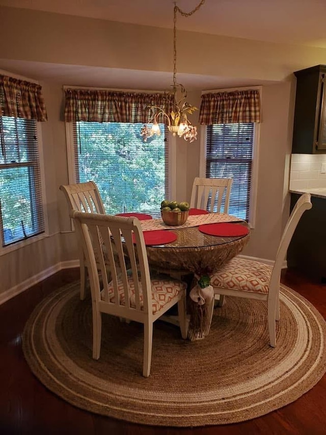 dining space with baseboards and a notable chandelier