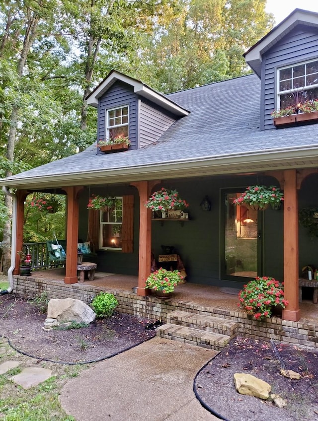 exterior space with roof with shingles and a patio