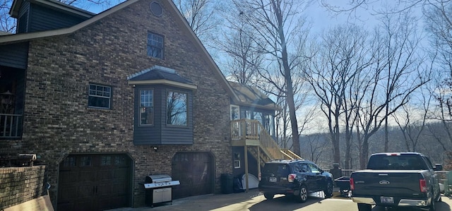 view of home's exterior with stairs, brick siding, and an attached garage