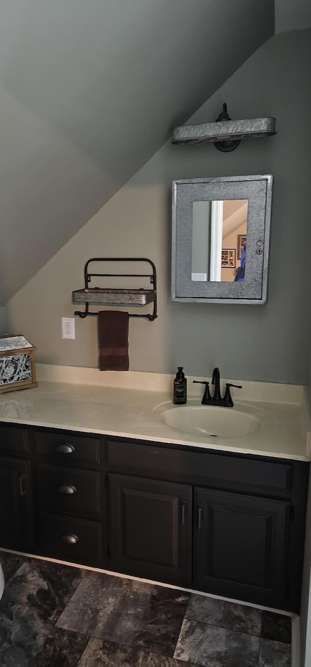 bathroom with vaulted ceiling and vanity