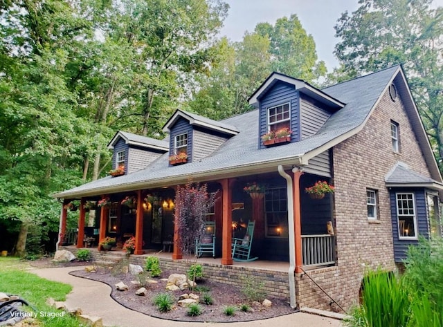 view of front of house featuring a porch and brick siding