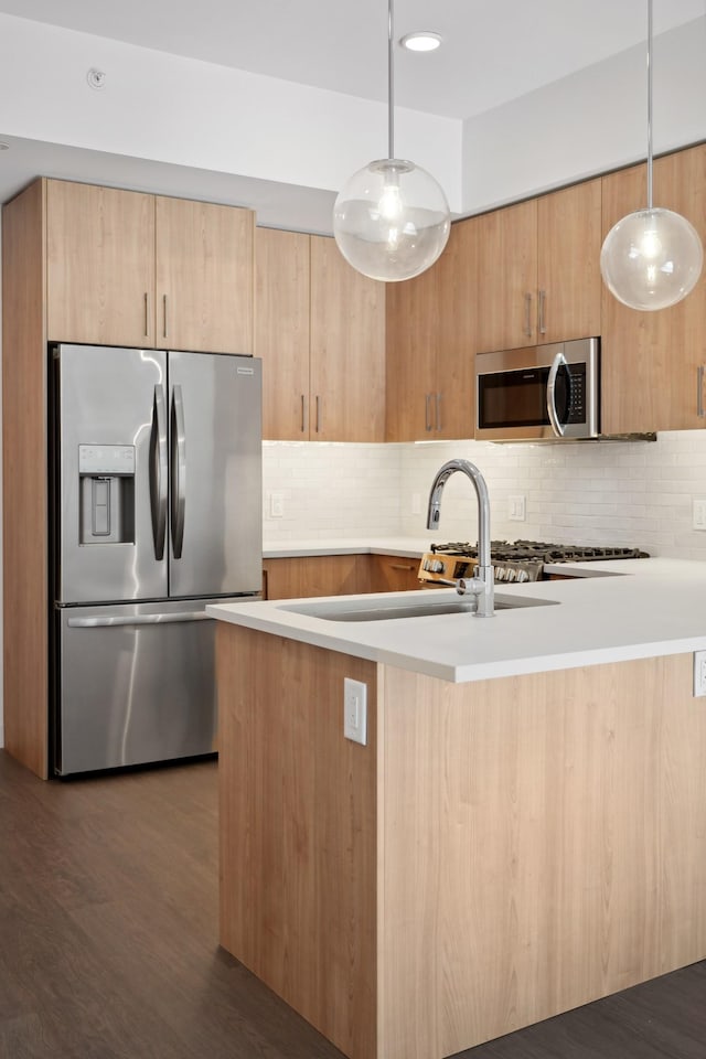 kitchen with decorative light fixtures, stainless steel appliances, dark hardwood / wood-style flooring, light brown cabinetry, and tasteful backsplash