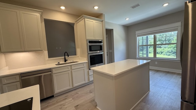 835 Stovers Gln, Murfreesboro, TN 37128 - kitchen featuring stainless steel appliances, light countertops, light wood-type flooring, a kitchen island, and white cabinetry