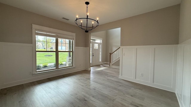 835 Stovers Gln, Murfreesboro, TN 37128 - unfurnished dining area featuring a chandelier, wainscoting, a decorative wall, light wood-type flooring, and stairs