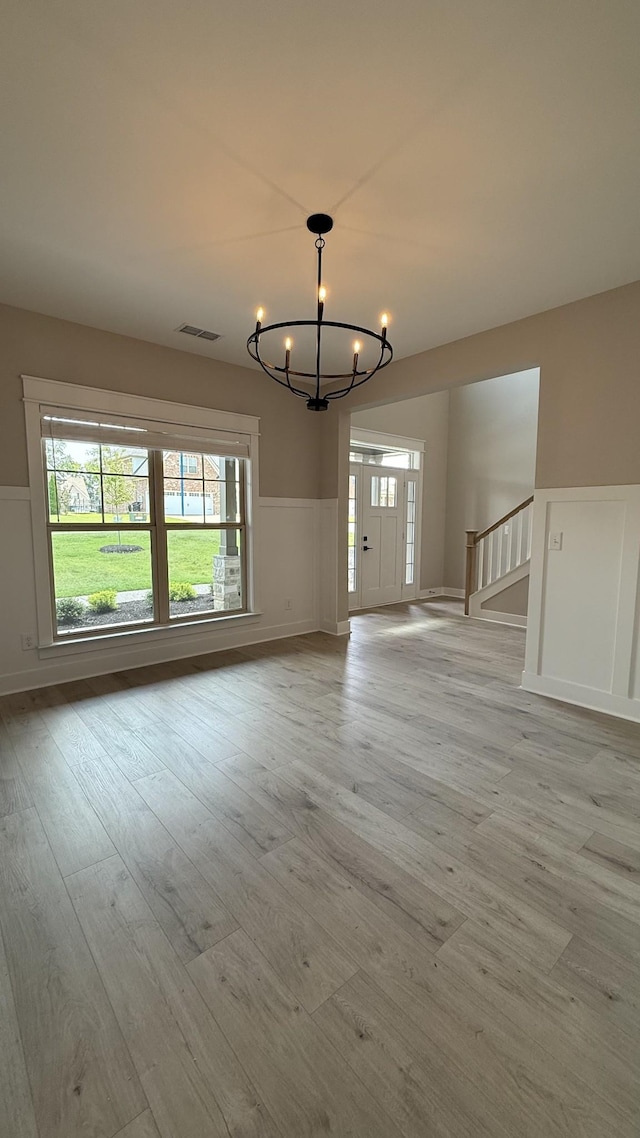 835 Stovers Gln, Murfreesboro, TN 37128 - unfurnished dining area featuring a chandelier, light wood finished floors, wainscoting, plenty of natural light, and stairs