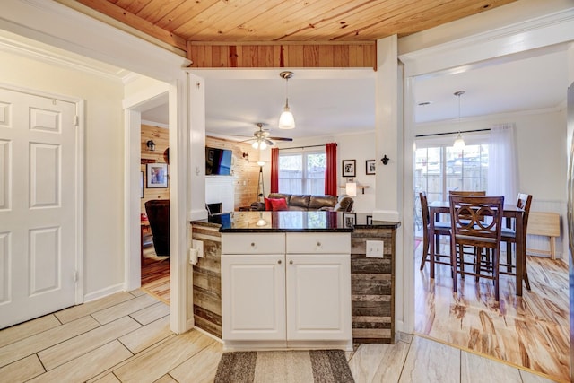 kitchen featuring decorative light fixtures, white cabinetry, ornamental molding, wood ceiling, and light wood-type flooring