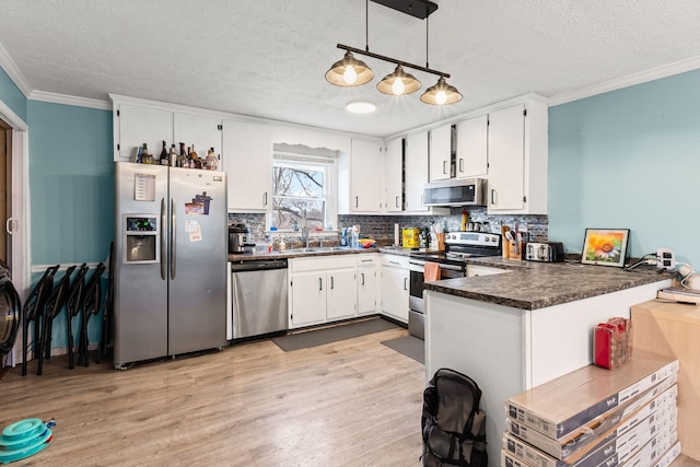 kitchen featuring appliances with stainless steel finishes, decorative light fixtures, sink, white cabinets, and ornamental molding