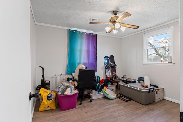 misc room featuring ornamental molding, light hardwood / wood-style floors, and a textured ceiling