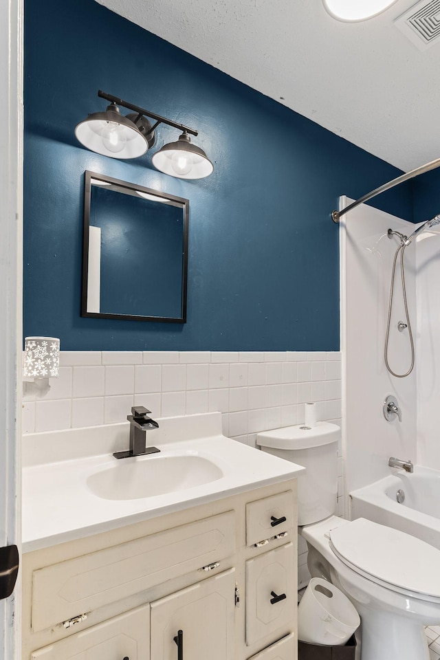 full bathroom with vanity, shower / bathing tub combination, tile walls, and toilet